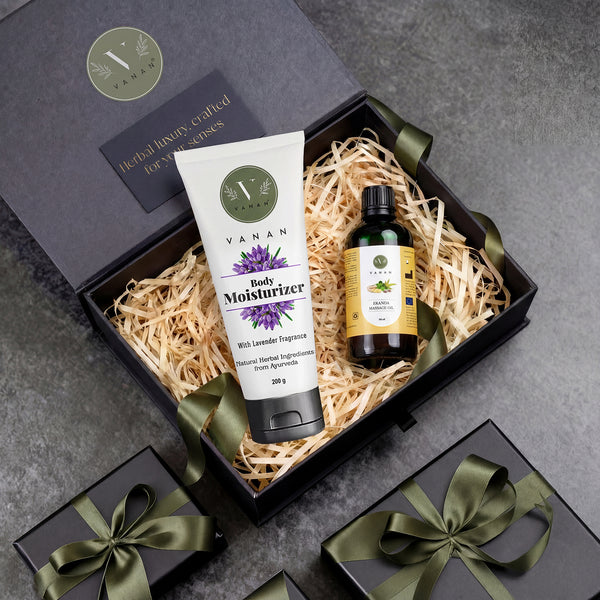 Gift set with Vanan body moisturizer and oil in a decorative box on a gray surface.