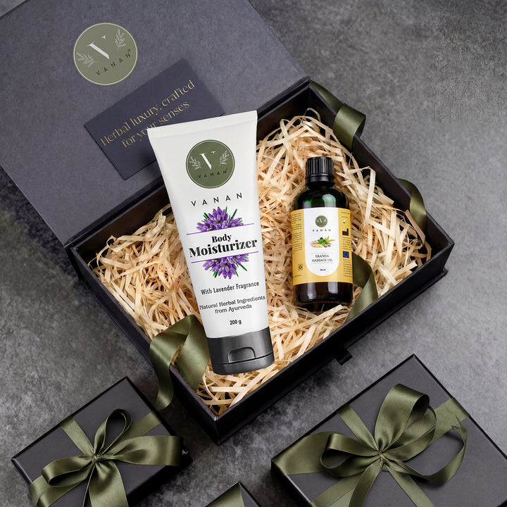 Gift set with Vanan body moisturizer and oil in a decorative box on a gray surface.