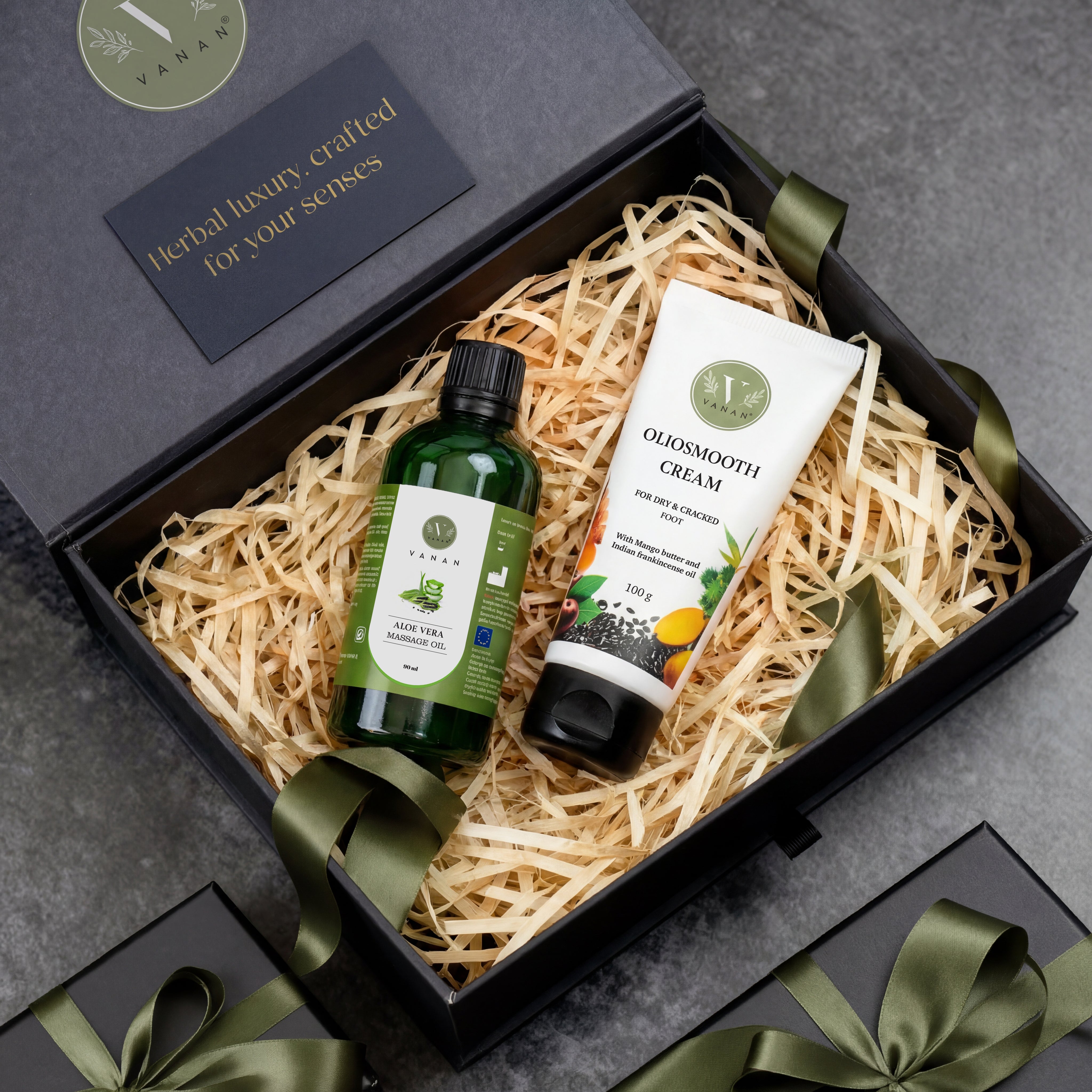 Gift set with a bottle and tube of cream in a decorative box on a gray surface