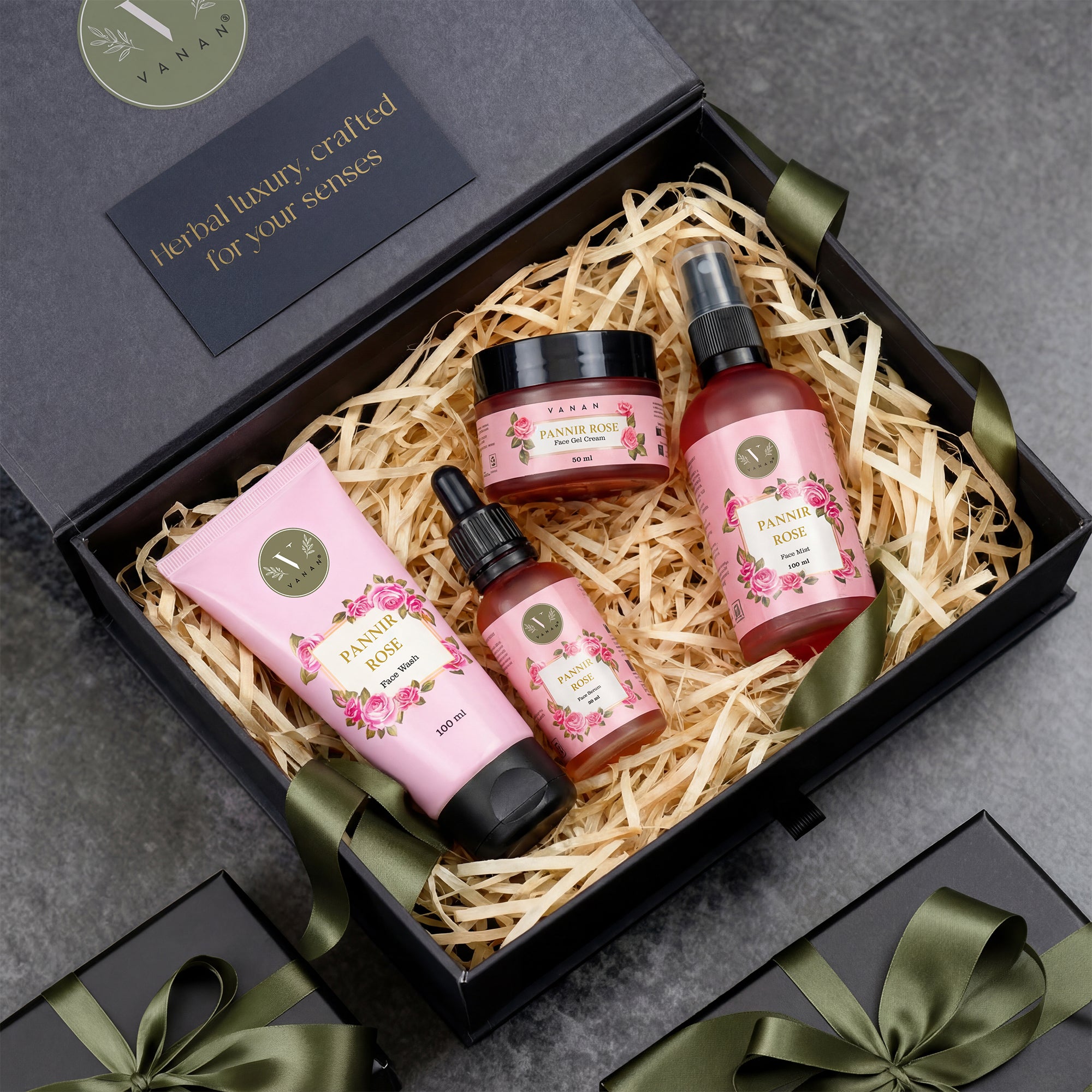 Set of skincare products including a bottle, jar, and lotion in a decorative box with a ribbon.